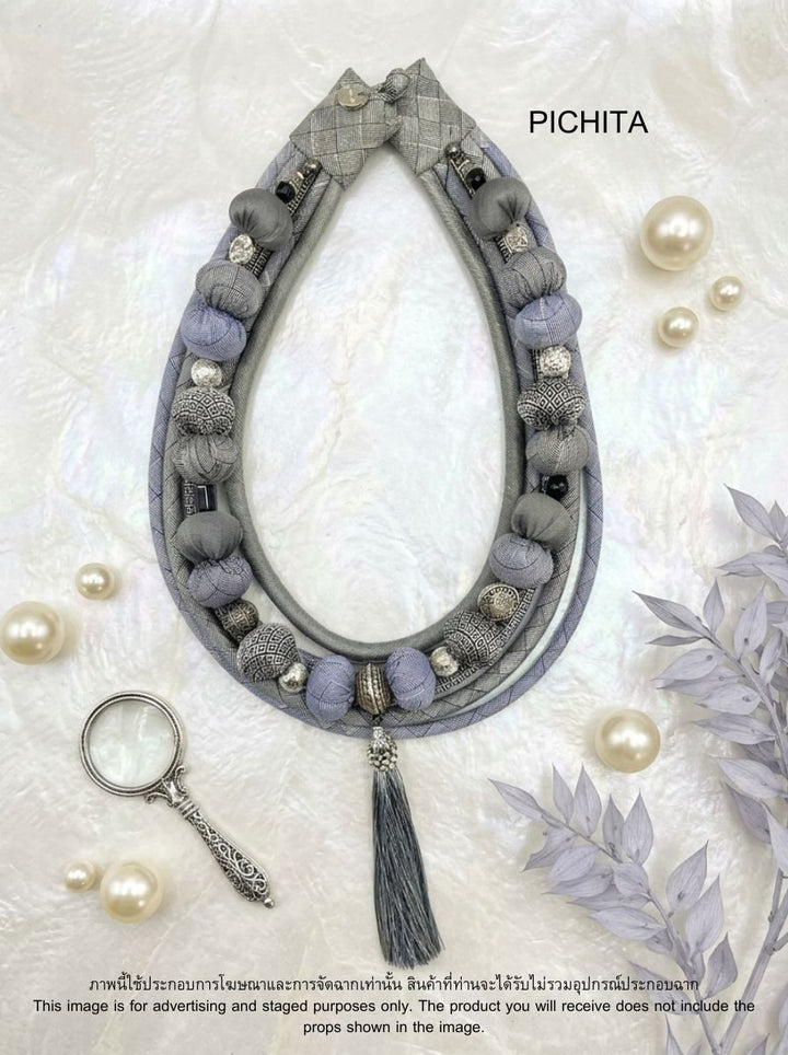 Bohemian-style light gray fabric bead necklace.