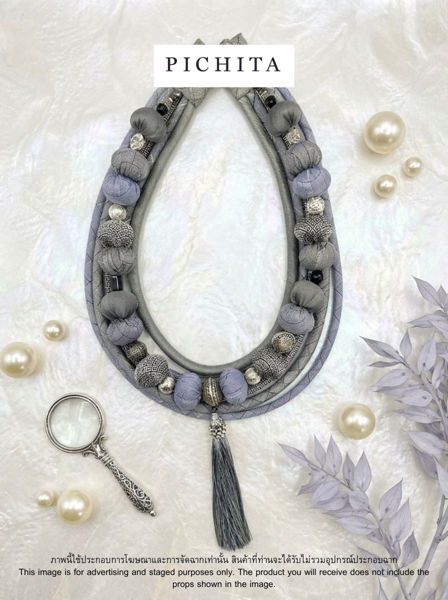 Bohemian-style light gray fabric bead necklace.