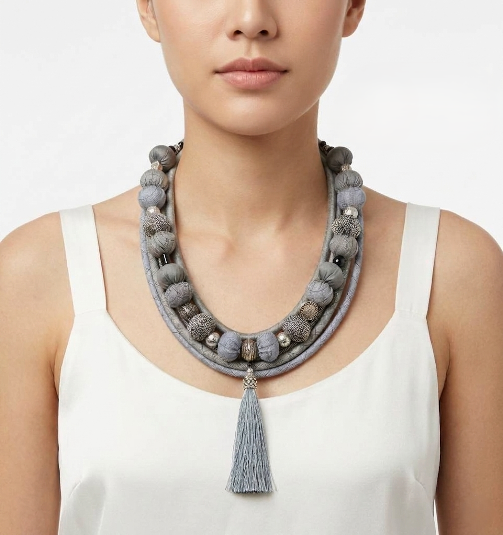Bohemian-style light gray fabric bead necklace.
